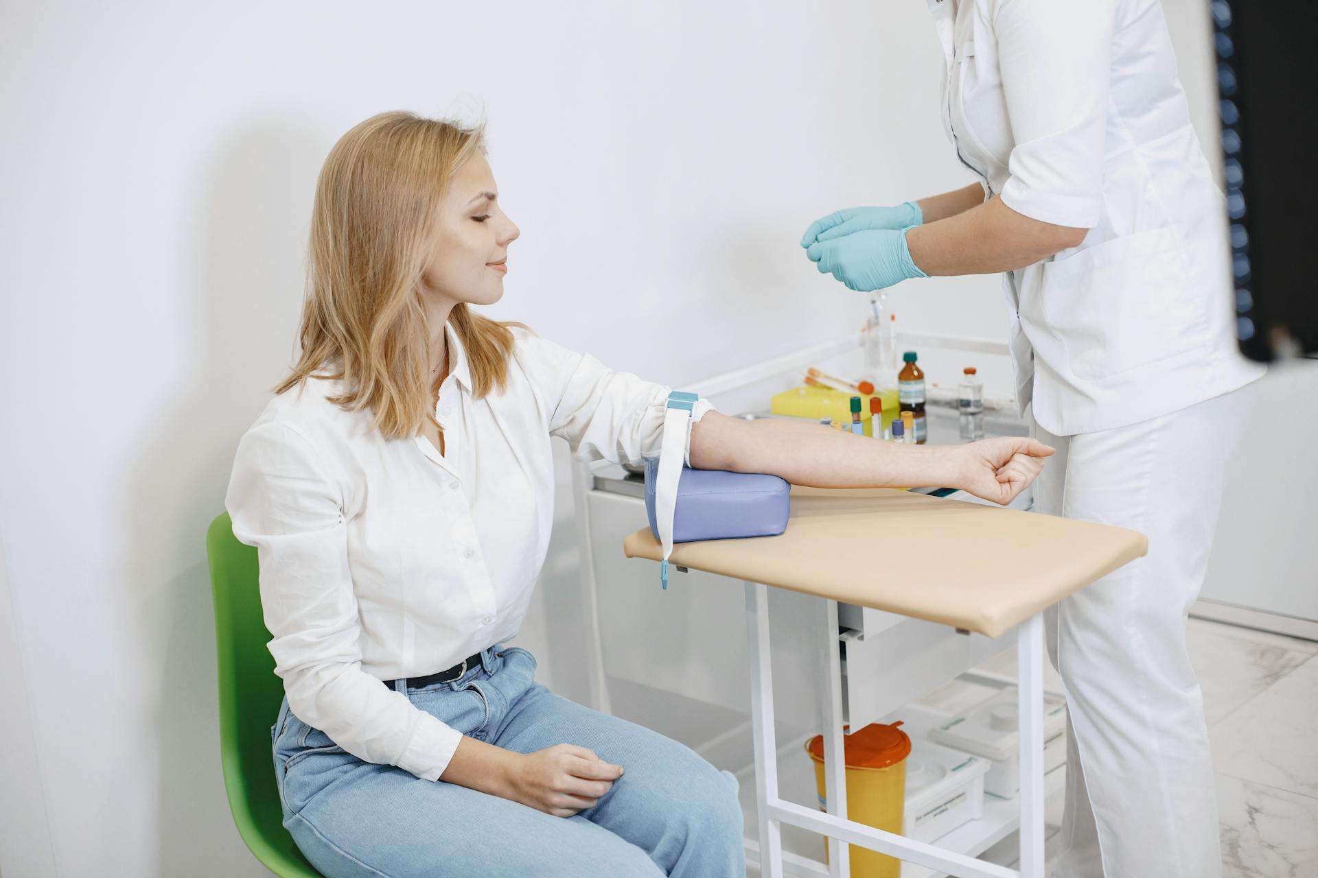 Technologiste médicale effectuant un prélèvement sanguin auprès d'une patiente